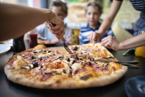 Kids sharing a large pizza at a restaurant.
