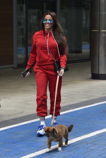 Katie Price walking her new dog Sid on a leash.