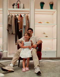 A man and young girl sitting in a chair in a store.