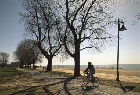 Woman cycling along a beach path.