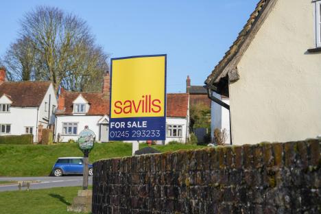 Savills for sale sign in front of houses.