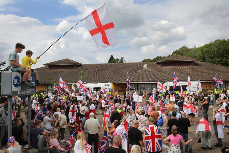 Protestors demonstrating outside an asylum hotel.