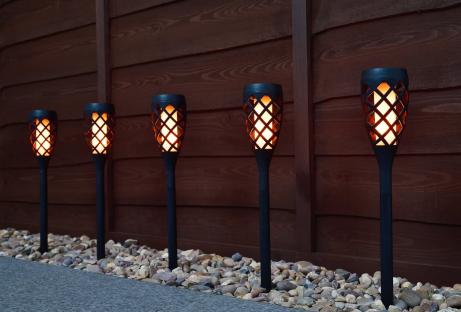 Five solar-powered post lights illuminating a garden path.