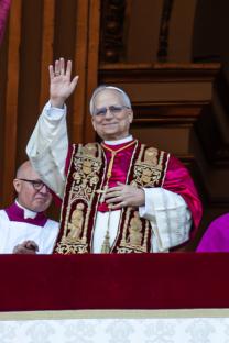 A cardinal waving from a balcony in St. Peter's Square.