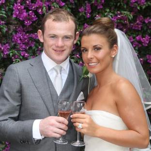 Wayne Rooney and Coleen Rooney toasting with champagne on their wedding day.