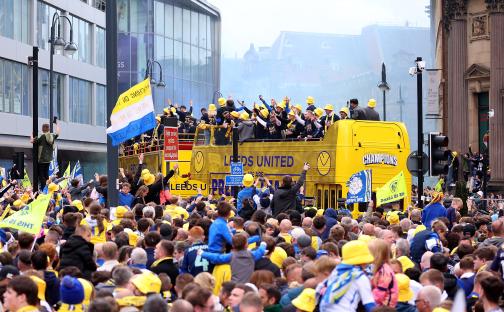 Leeds United players celebrating on a bus during a victory parade.