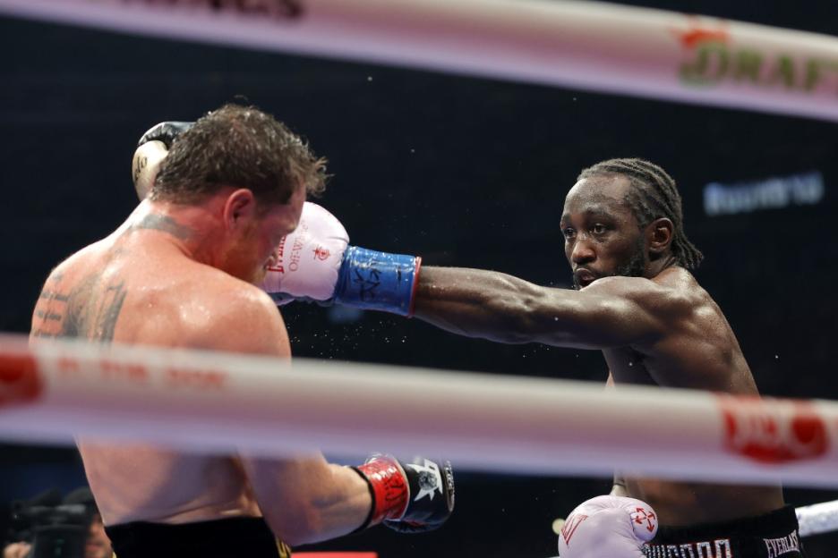 Terence Crawford landing a punch on Canelo Alvarez in a boxing match.