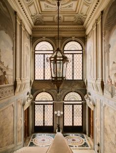 Grand staircase with stained-glass windows and ornate details.