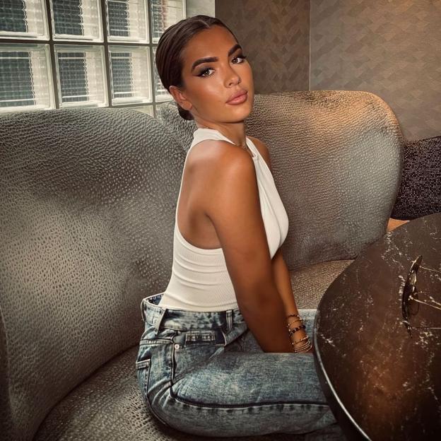 Gemma Owen in a white top and jeans.