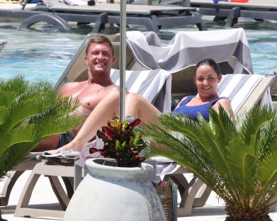 Jacqueline Jossa and Dan Osborne sunbathing by a pool.