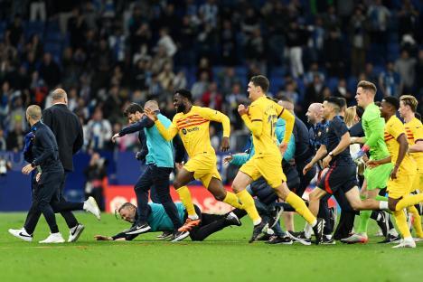 FC Barcelona players and staff running off the field.