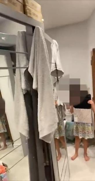 A child filming a room with mirrors and clothes hanging, with The Sun and SWNS logos.