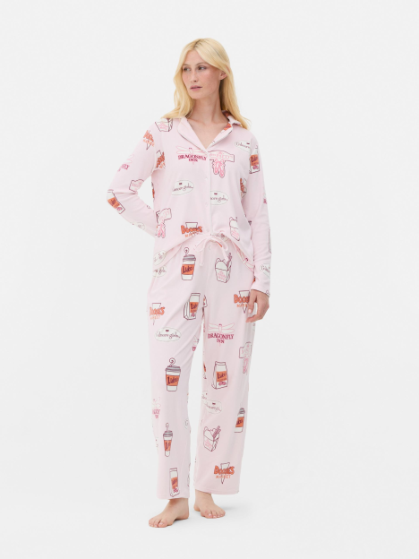 Woman in pink pajamas with Gilmore Girls print.