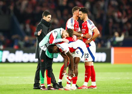 Arsenal soccer players comforting an injured teammate.