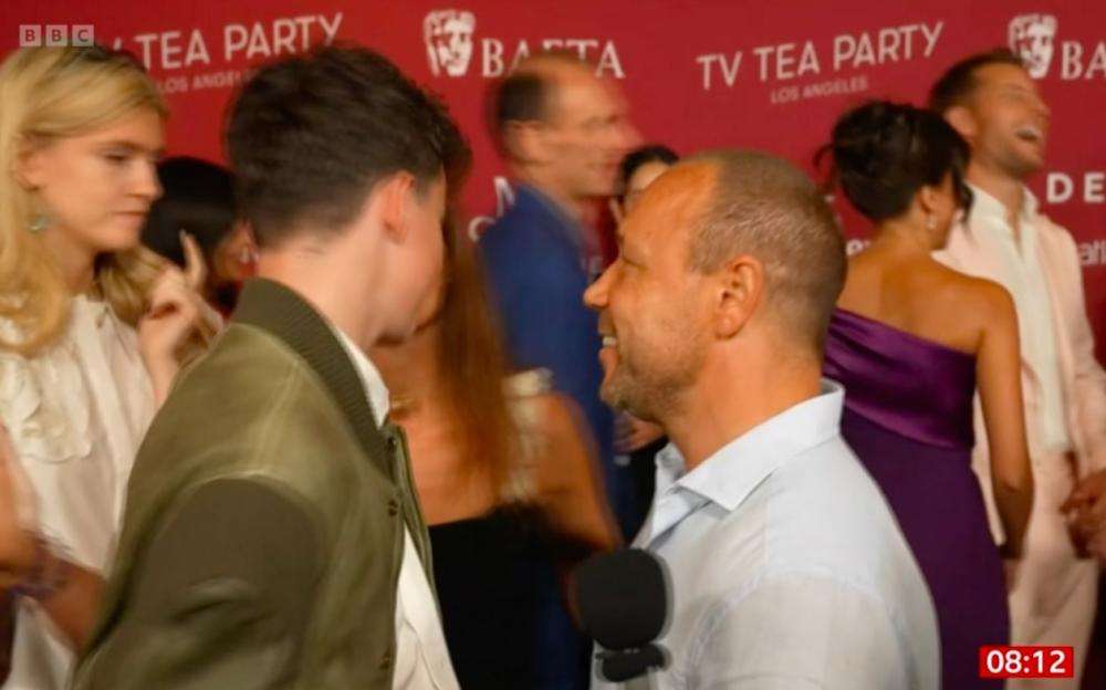 A young man being interviewed at an awards ceremony.