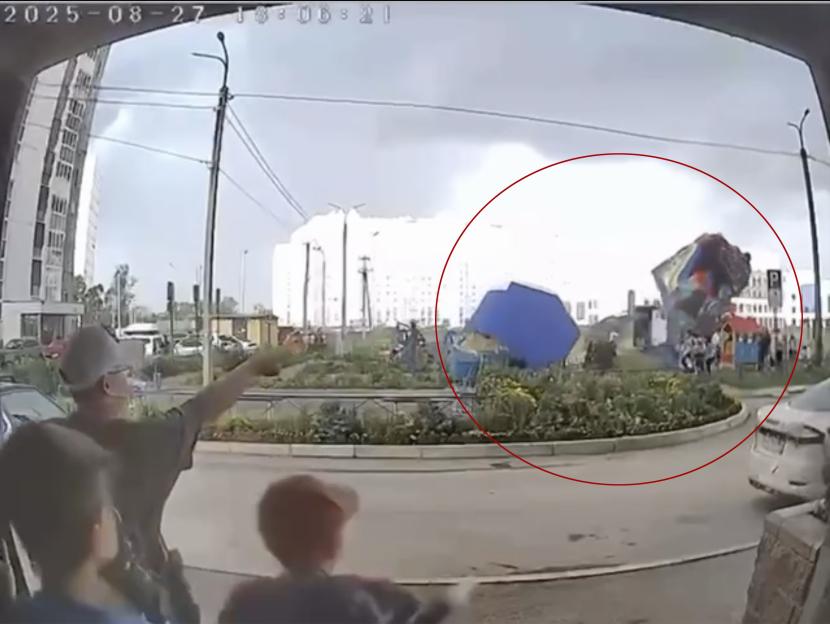 Bouncy castle with children inside lifted into the air by strong winds.