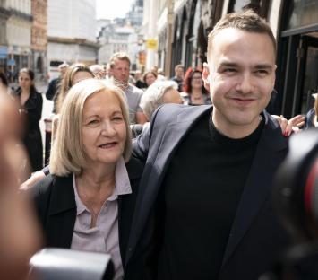 A woman and her son at a press conference.