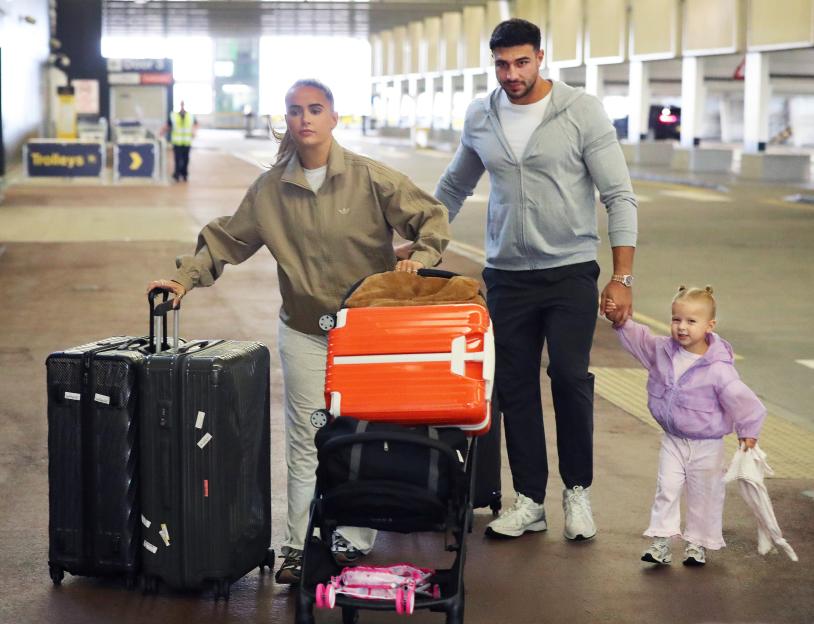 Molly-Mae Hague, Tommy Fury, and their daughter at an airport.