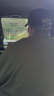 Man in a car wearing a baseball cap.