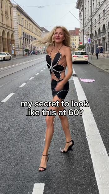 Woman in a flower-shaped top and short skirt walking on a city street.