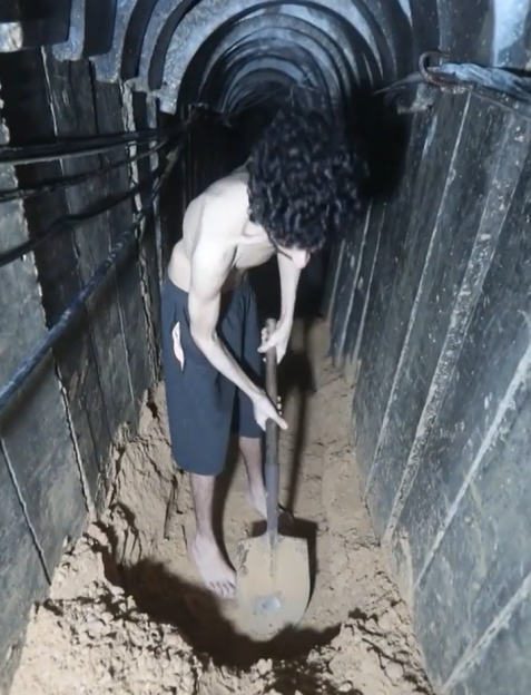 Person digging in a narrow tunnel.