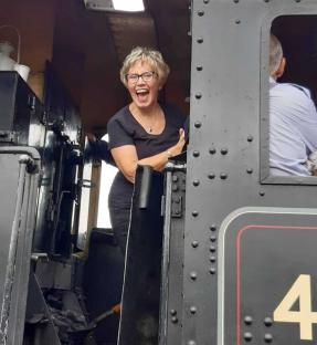 Woman smiling in a train cab.