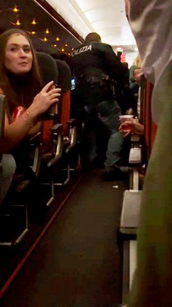 Disruptive passenger clutching vodka being dragged off an EasyJet flight by police.