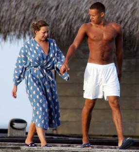 a shirtless man and a woman are holding hands