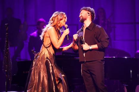 Delta Goodrem and a male vocalist performing on stage.