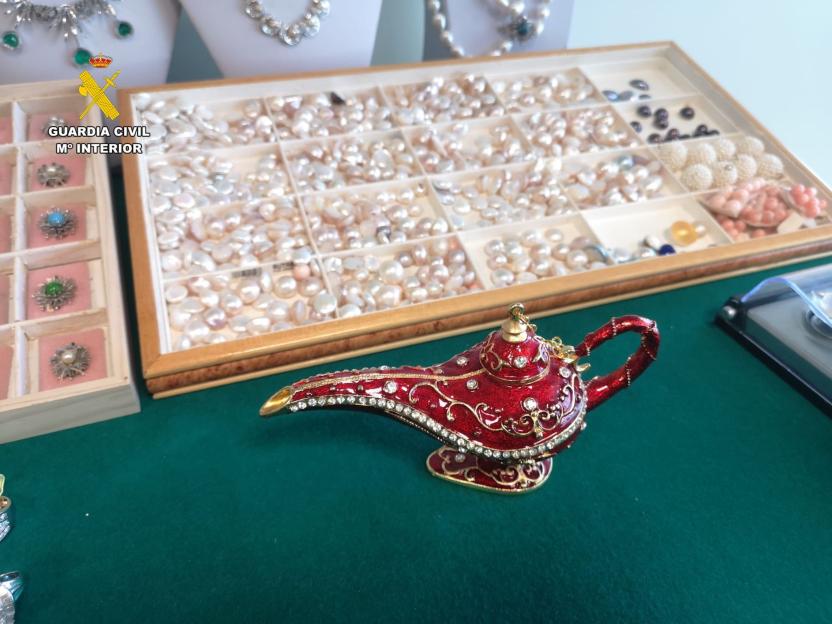 Jewelry recovered by police from the Tenerife Airport theft, including a decorative red genie lamp, pearls, and brooches.