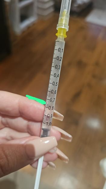 Close-up of a hand holding a syringe.