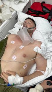 Injured groom in hospital bed on oxygen.