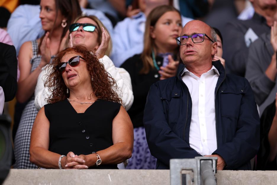 Isabel and Joaquim Silva, brothers of Diogo Jota, react to applause at a soccer match.
