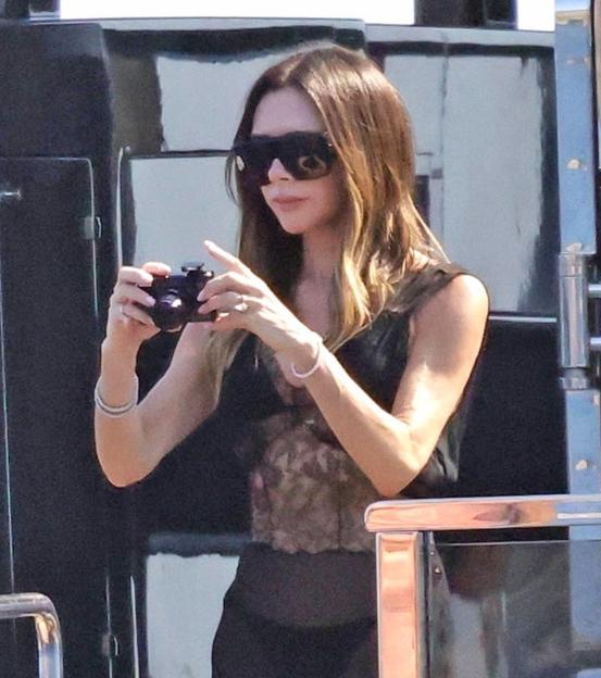 Victoria Beckham taking photos on a yacht.