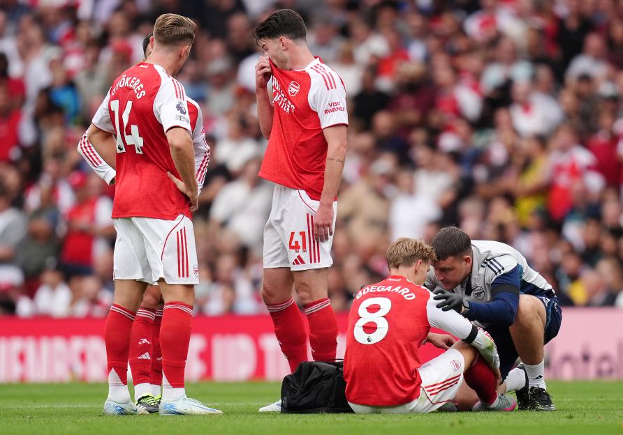 Arsenal's Martin Ødegaard receiving medical attention on the field.
