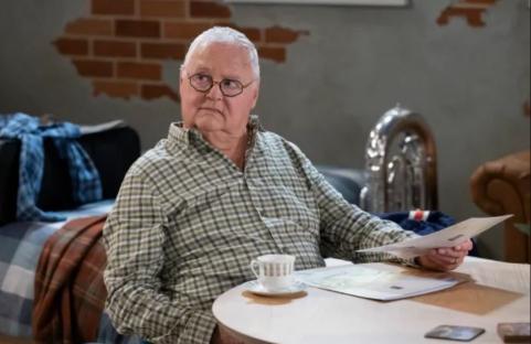 Harold from Neighbours looking at papers.