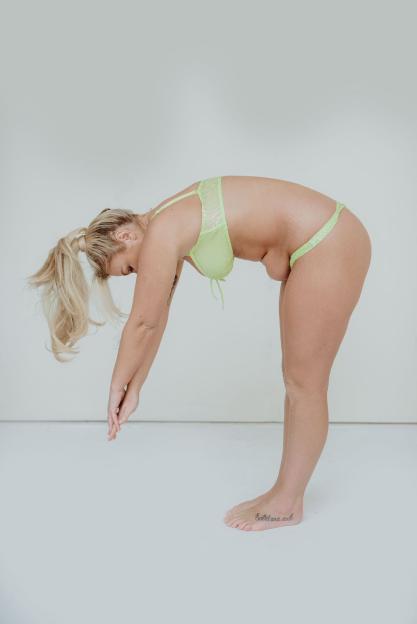 Woman in lime green lingerie bending over.