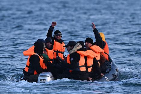 Migrants in a small boat at sea.