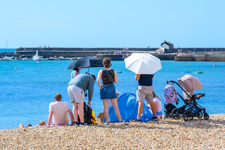 People relaxing on a sunny beach under parasols.