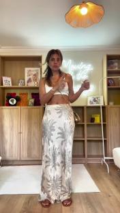 Woman modeling a long patterned skirt and white crop top.