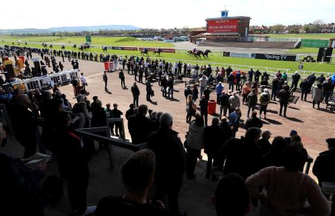 Racegoers watching a horse race at Redcar Racecourse.