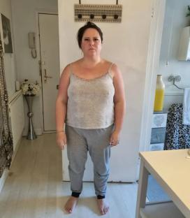Full-length photo of a woman in a tank top and sweatpants.