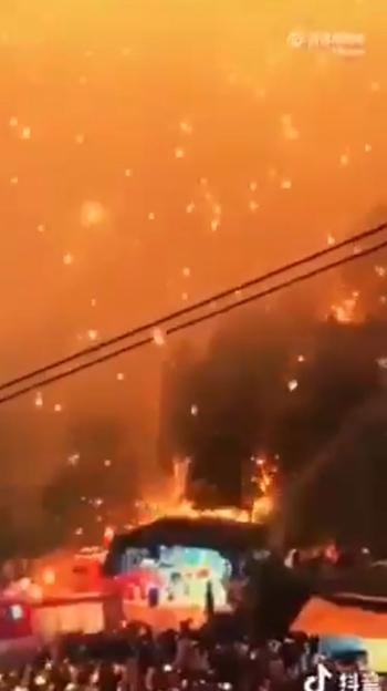 Out-of-control fireworks falling onto a crowd and structures below.