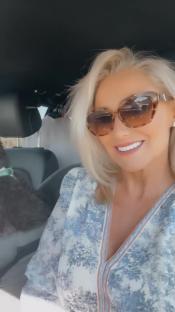 Screenshot of a woman in a car with a dog.