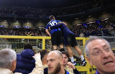 Davide Frattesi of FC Internazionale celebrating a goal by climbing a fence.