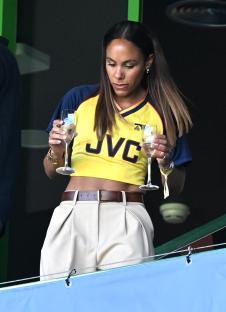 Alex Scott holding two champagne flutes.