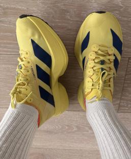 Yellow running shoes with navy blue accents.