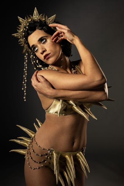 Woman in gold costume and headdress.