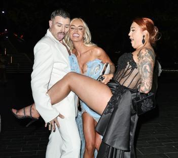 Three people leaving a BAFTA TV awards ceremony.