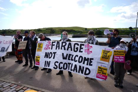 Protestors in Aberdeen, Scotland hold signs that read 